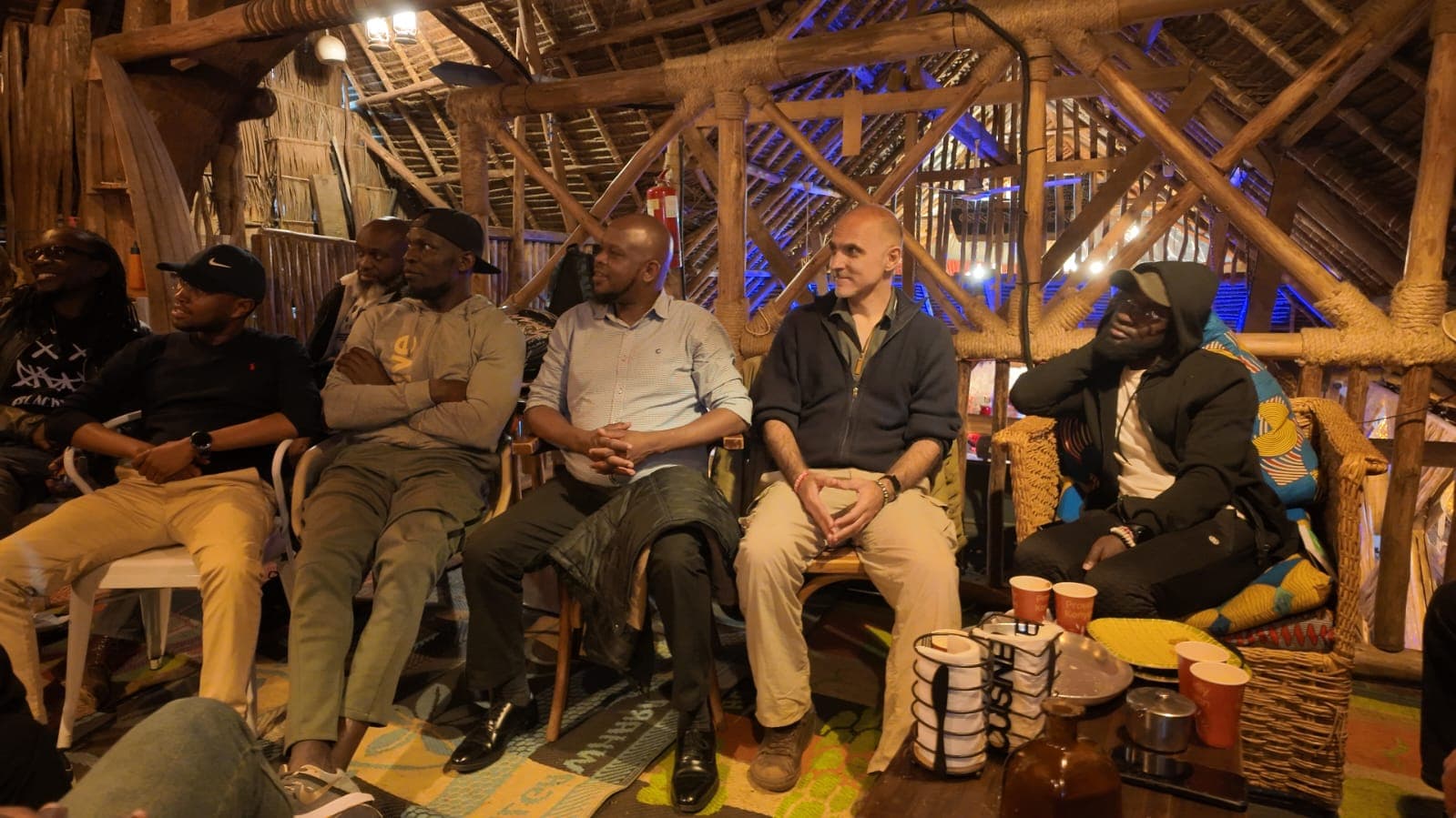 A circle of men in quiet conversation, listening closely to one another